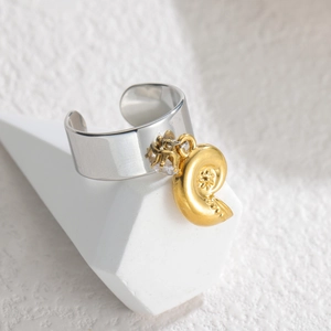 Vue détaillée d'une bague ouverte en argent avec un pendentif coquillage doré et gemme