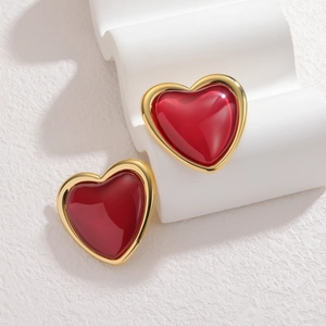 Elegant vintage red heart studs with gold frames on a minimalist white textured stand