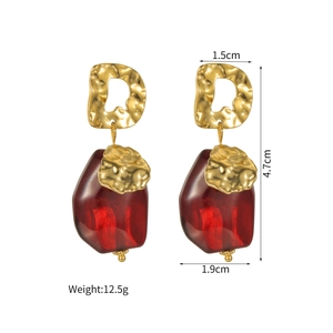 Detailed view of red faceted glass earrings with gold textured metal measuring 4.7cm in height