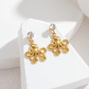 Elegant gold octopus drop earrings with sparkling zircon on textured stone base