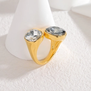Modern gold open ring featuring large contrasting black and clear faceted zircons