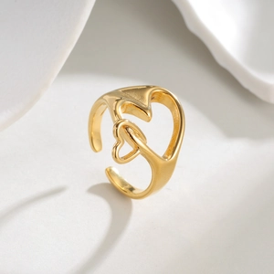 Bague ouverte dorée minimaliste avec double cœur entrelacé sur un socle en pierre