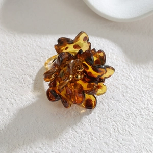 Vintage leopard print resin flower ring with golden metal base on a stone texture