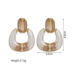 Vue détaillée des boucles d'oreilles vintage avec émail marbre blanc et bord doré