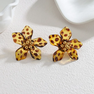 Macro detail of amber acrylic floral earrings with leopard pattern and golden beaded center