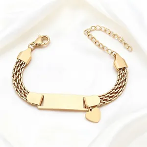 Gold 8mm mesh chain bracelet with engravable bar and heart charm on silk fabric