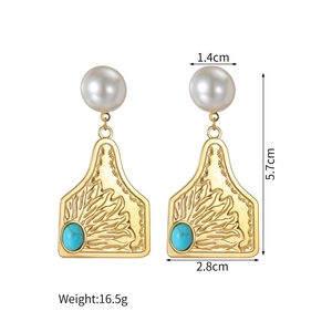 Detailed view of vintage gold earrings with turquoise stones and white pearls