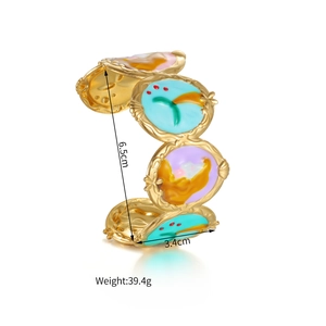 Detailed close-up of a gold geometric cuff bracelet with colorful enamel oval modules