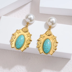 Detailed macro shot of vintage gold earrings with pearls, turquoise and marine motifs