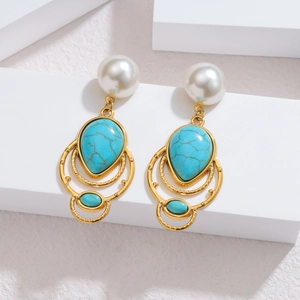 Close-up of vintage gold earrings with white pearls and turquoise stones in a drop design