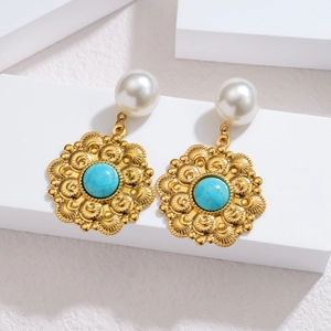 Detail of vintage gold earrings with faux pearl stud and turquoise relief pendant