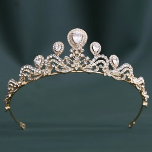 Détail d'une couronne de mariée dorée avec zircons AAA sur fond en tissu vert foncé