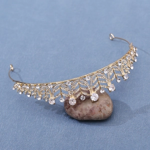 Close-up of golden bridal crown with sparkling cubic zirconia on natural pebble stone