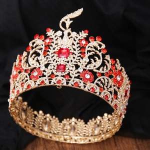 Detailed macro view of golden baroque crown with red crystals and peacock patterns