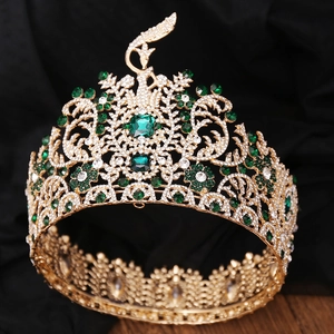Macro shot of gold baroque tiara featuring green gems and intricate peacock design details