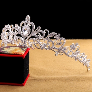 Detailed view of silver bridal tiara with rhinestones resting on a luxury jewelry box