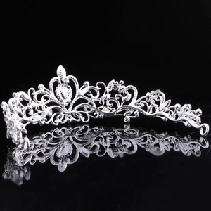 Detailed close-up of a silver baroque tiara with rhinestones on a black mirror base