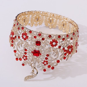 Macro shot of golden baroque tiara with red rubies and detailed peacock pendant