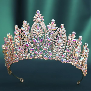 Close-up of golden crown featuring iridescent AB crystals on vintage green velvet