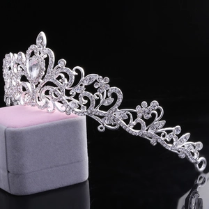 Detailed side view of silver bridal crown with crystals on pink velvet jewelry box