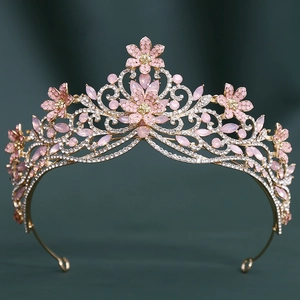 Détail d'une couronne de mariée avec cristaux roses et base dorée sur velours vert