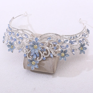 Couronne de mariée argentée avec fleurs en cristal bleu sur support à bijoux en velours