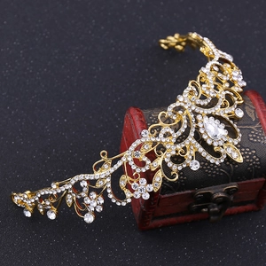 Close-up of golden bridal crown featuring intricate floral patterns and sparkling rhinestones