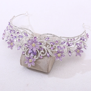 Détail d'une couronne de mariée argentée avec cristaux violets sur socle en velours