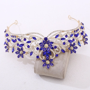 Gros plan d'une couronne de mariée dorée avec cristaux bleus et strass marquise