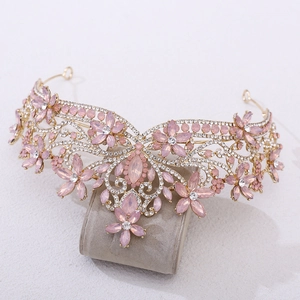 Detail of baroque crystal bridal crown with pink flower gemstones on golden base