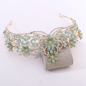 Détail d'une couronne de mariée dorée avec cristaux vert menthe et motifs floraux