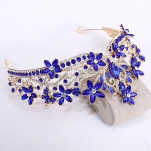 Close-up of golden baroque bridal crown with blue crystals and floral rhinestone patterns