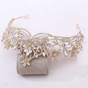Détail de la couronne de mariée dorée sertie de strass brillants sur son support gris