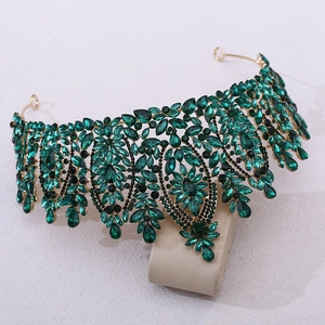 Macro detail of Baroque bridal crown with emerald green gems and gold setting