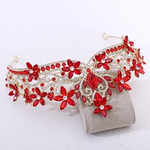 Detailed close-up of Baroque gold crown with red crystal flowers and sparkling rhinestones