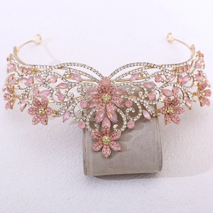 Vue macro détaillée du diadème de mariée fleur dorée avec cristaux roses sur support gris