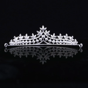 Detailed view of silver leaf crown with rhinestones and white pearls on black background