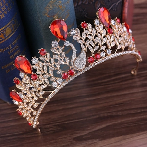 Vue détaillée d'une couronne de cygne baroque dorée avec cristaux rouges sur livres anciens