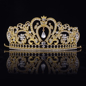 Diadème de mariée baroque doré avec strass et motif cœur sur surface réfléchissante noire