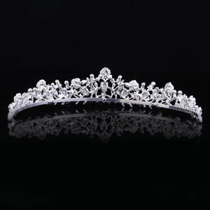 Dettaglio della tiara da sposa in argento con fiori bianchi e design a onde intrecciate