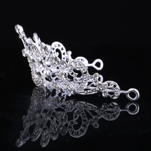 Classic curved silver bridal crown with shimmering crystals on a black reflective surface