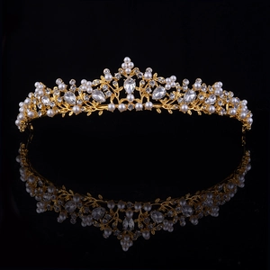 Dettaglio della corona da sposa con foglie dorate, perle bianche e strass scintillanti