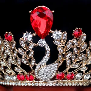 Vue macro de la couronne de cygne avec une grande gemme rouge et des strass dorés brillants