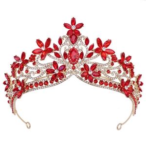 Close-up of golden baroque bridal crown with red crystal flowers and white rhinestones