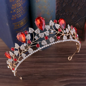Detailed macro view of baroque bridal crown with red rhinestones and gold leaf design