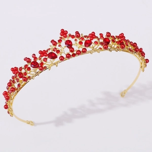 Dettaglio della corona da sposa dorata con perle rosse e cristalli lucenti fatti a mano