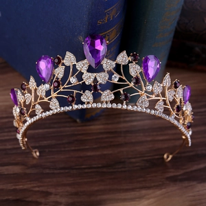 Baroque bridal crown with purple water-drop gems and gold leaf details on dark wood