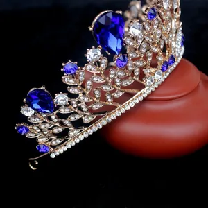 Détail d'une couronne baroque dorée sertie de cristaux bleus sur un support en poterie