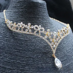 Detailed macro view of gold bridal necklace with sparkling pear-cut rhinestone pendant