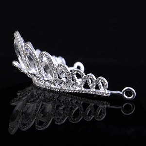 Elegant silver bridal tiara with sparkling crystal rhinestones on reflective black surface